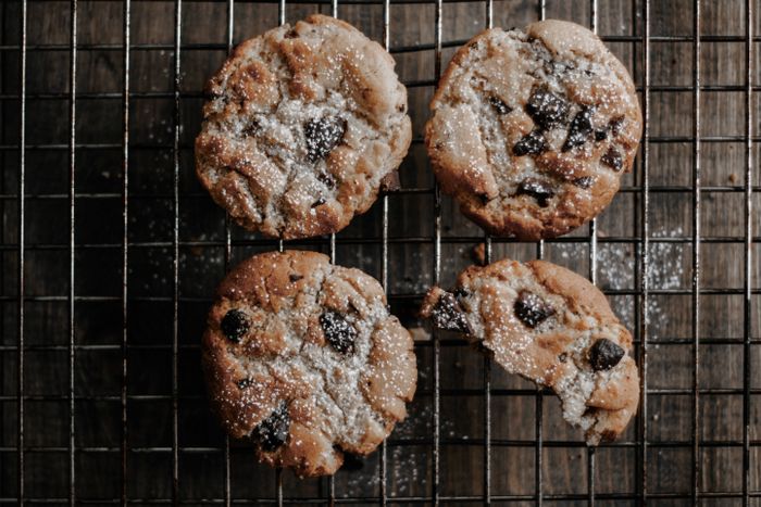 An overhead flatlay of chocolate chip cookies dusted with sugar.