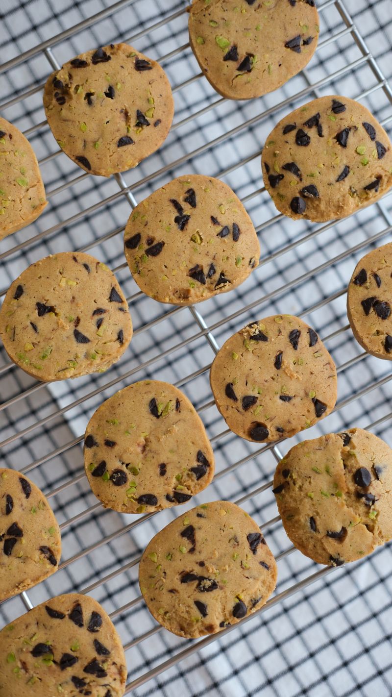 Freshly baked chocolate chip cookies cooling on a wire rack.